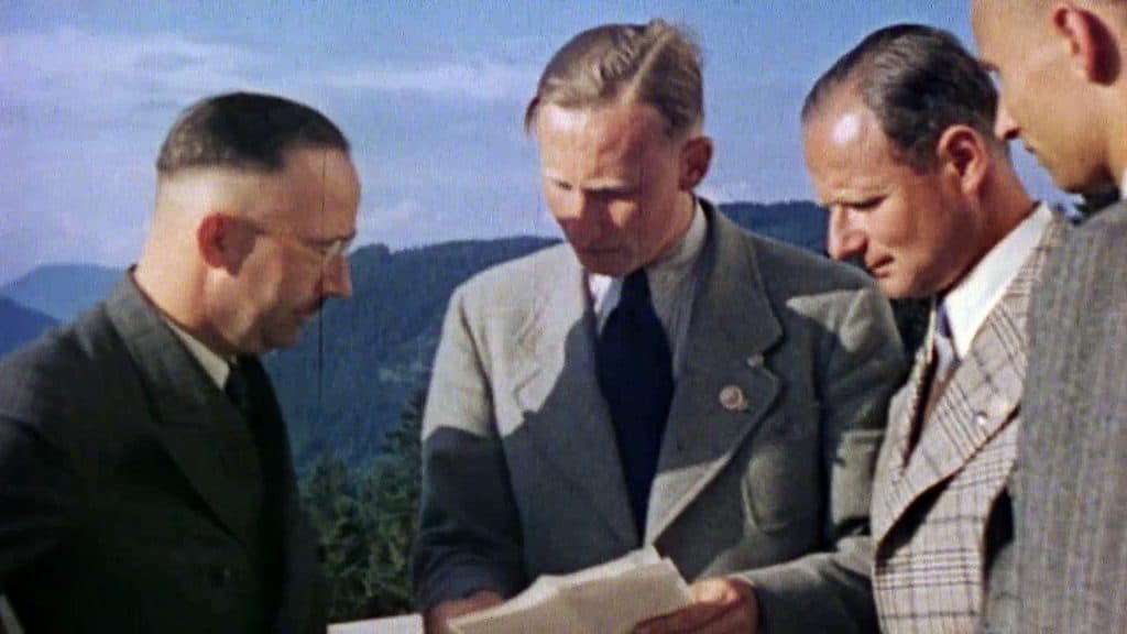 Historical image including SS leaders such as Himmler and Heydrich; artifacts like Himmler’s calling card survive from Himmler’s house.