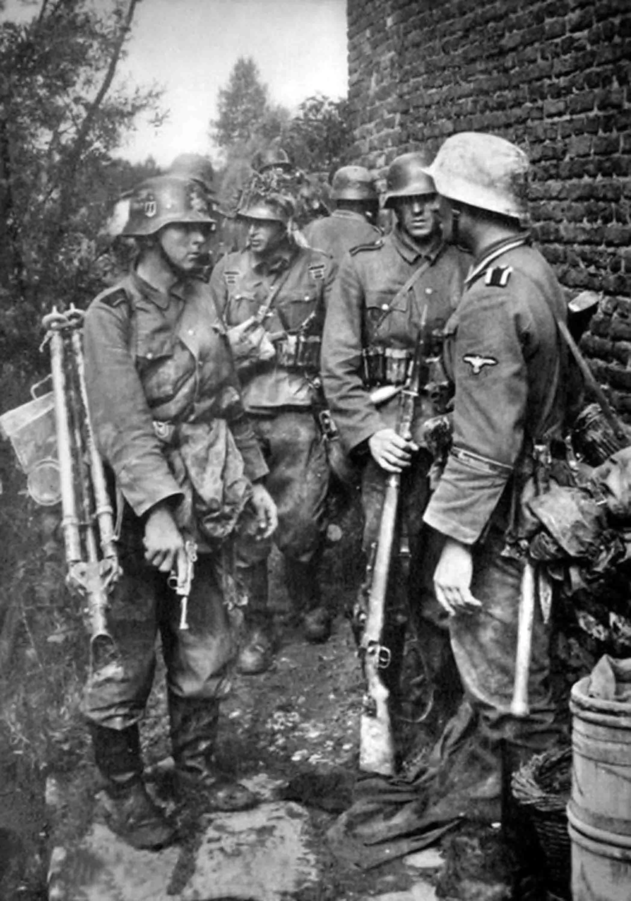 Soldiers - MG34 machine gun team - from the SS-Infanterie-Regiment "Germania" of SS-Freiwilligen-Division "Wiking" preparing for battle in the village