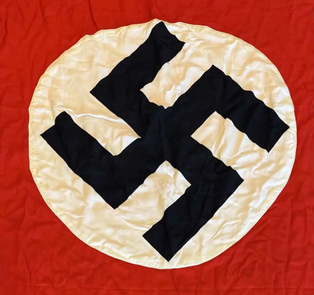 Swastika symbol on a historical flag with a red background and white circle.