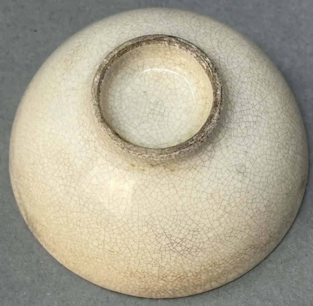 Vintage ceramic vessel with crackled glaze and circular opening.