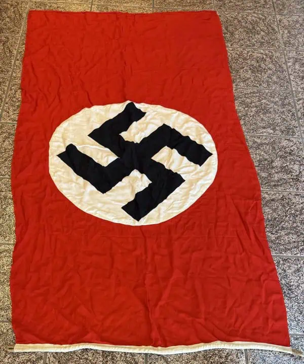 Swastika Nazi flag with red background and black swastika symbol on white circle.