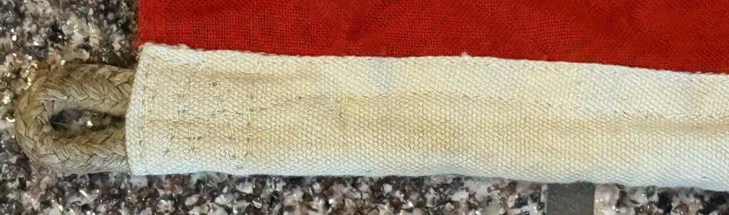 A soldier's sword with a leather-wrapped handle and a metal blade on a red background.